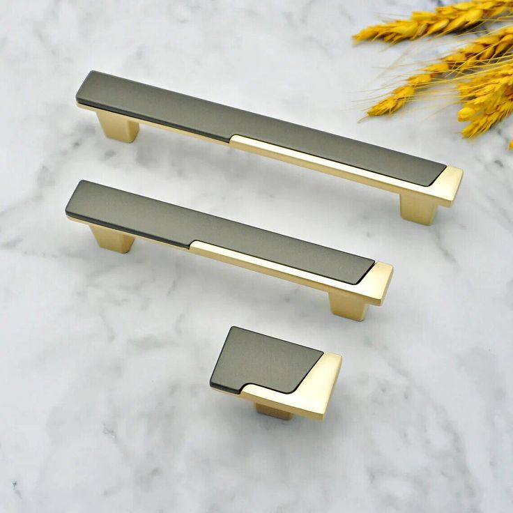 two brass handles on a marble counter top