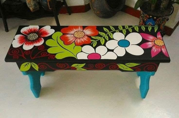 a painted bench sitting on top of a white floor