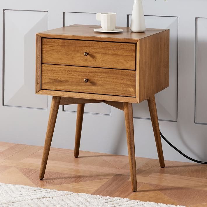 a small wooden table with two drawers and a white vase sitting on top of it