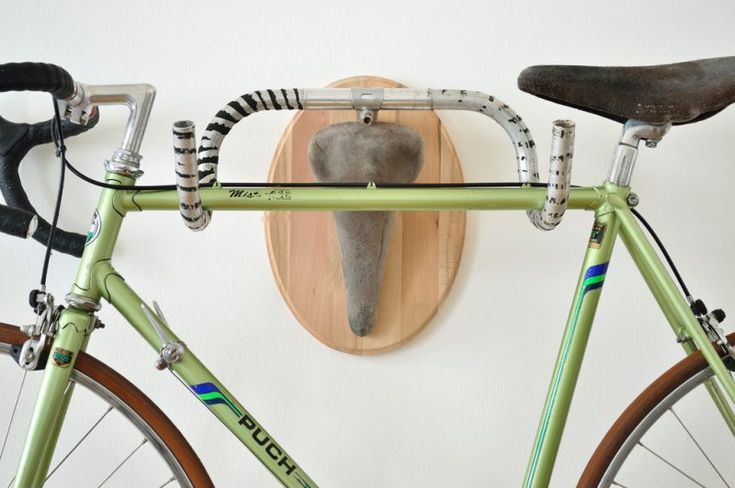 a green bike with an elephant's head mounted to the wall