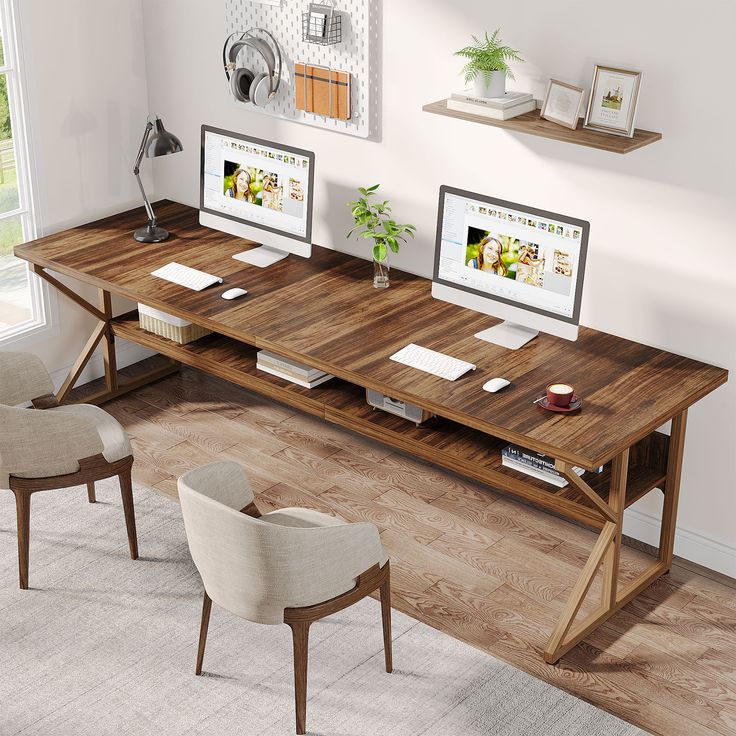 a computer desk with two monitors on top of it and some chairs in front of it