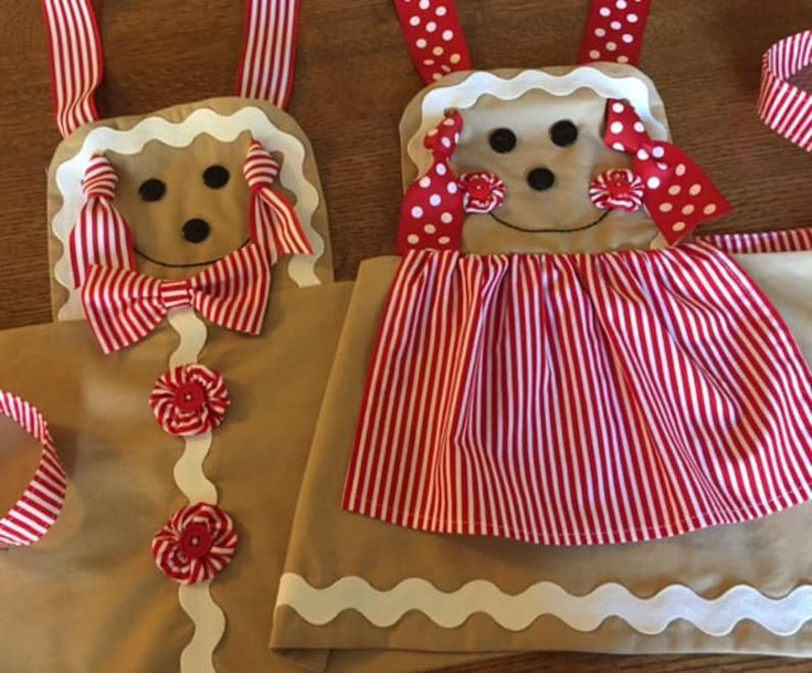 two little dogs made out of brown paper bags with red and white bows on them