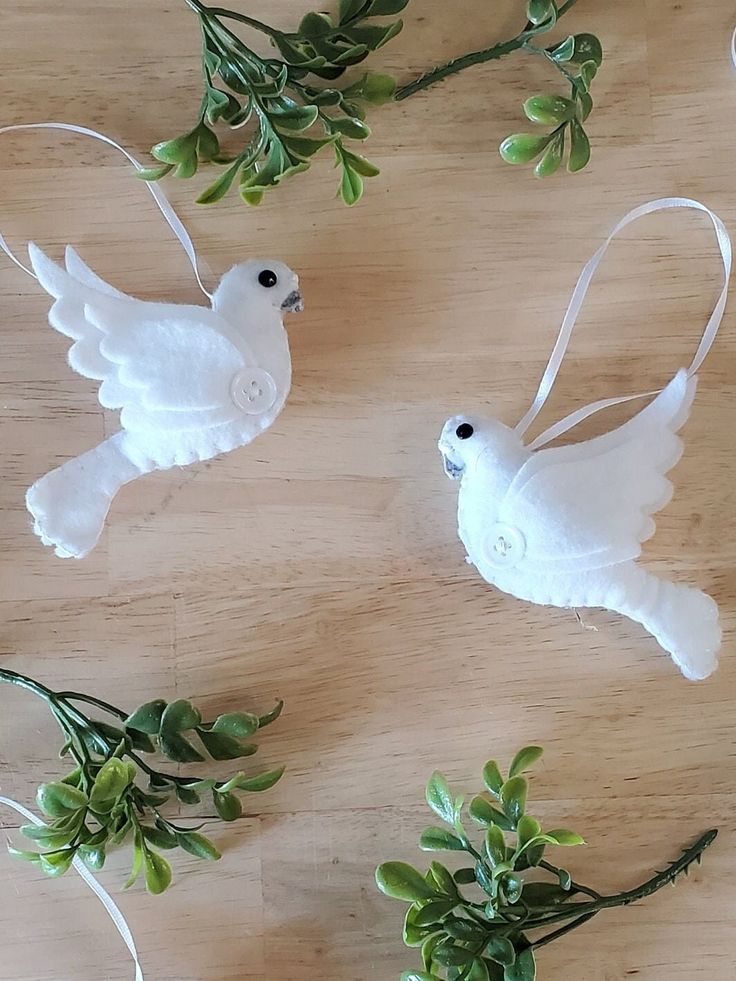 three white dove ornaments on a wooden table