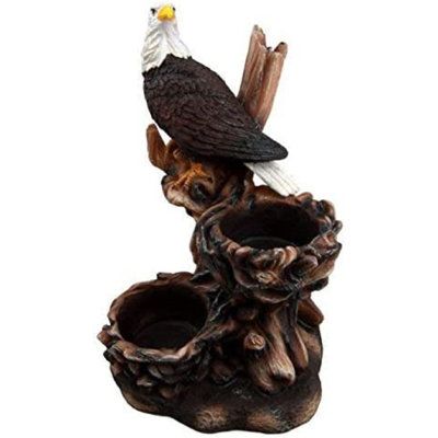 an eagle sitting on top of a tree stump with a nest in it's beak