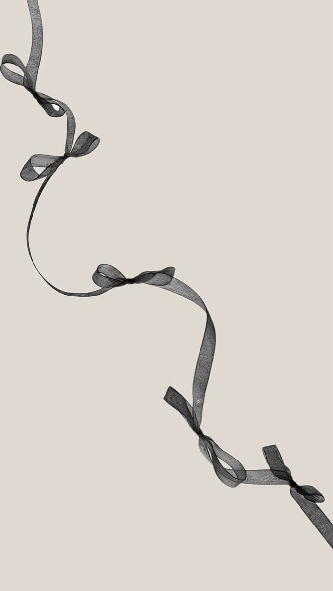 a black and white photo of a ribbon on a light gray background with the word love written below it