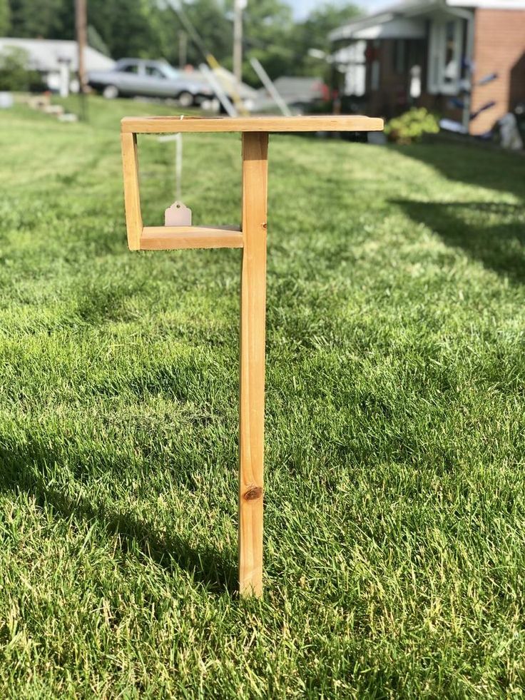 a wooden post in the middle of some grass