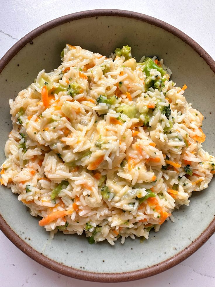 a bowl filled with rice and vegetables on top of a table