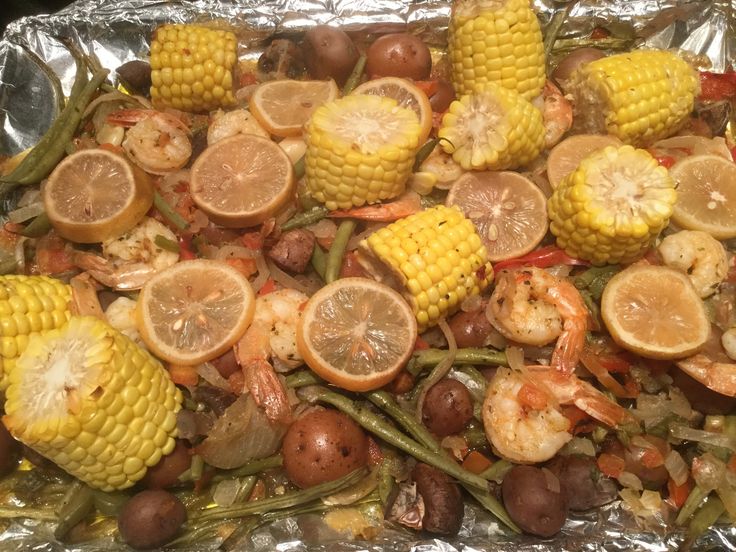 corn on the cob with shrimp, potatoes and green beans in foil wrapper