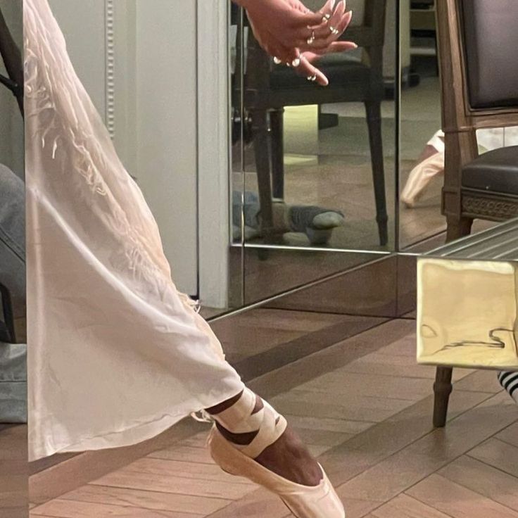 a woman is dancing on the floor in front of a mirror with her legs stretched out