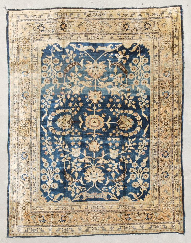 an antique rug with blue and beige colors