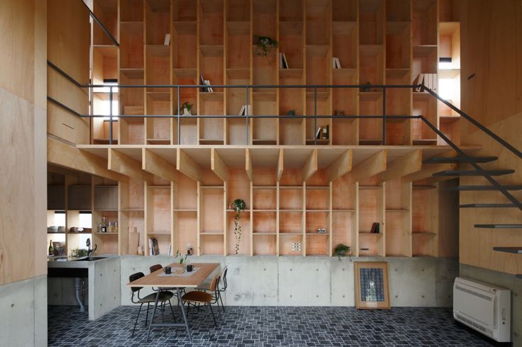 a room that has some shelves on the wall and a table with chairs in it