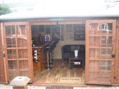 the inside of a wooden shed with lots of glass doors