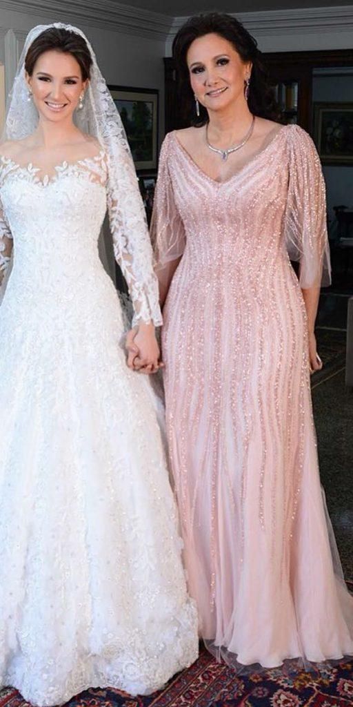 two women standing next to each other in wedding gowns and holding hands with one another