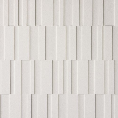 a white tile wall with vertical lines on it's sides and diagonals in the middle