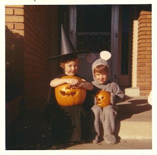 two children in halloween costumes holding pumpkins