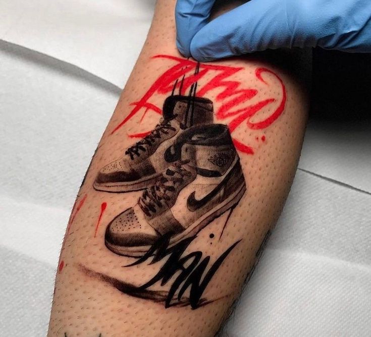 a person with a tattoo on their arm has a pair of sneakers painted on it