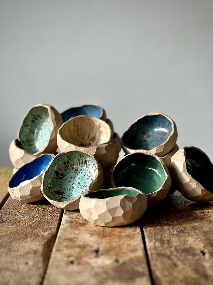 several bowls sitting on top of a wooden table next to each other with blue and green designs