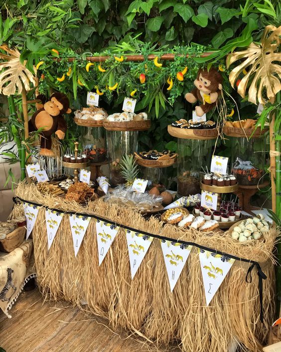 an outdoor dessert table with cupcakes, cookies and other treats on it's display