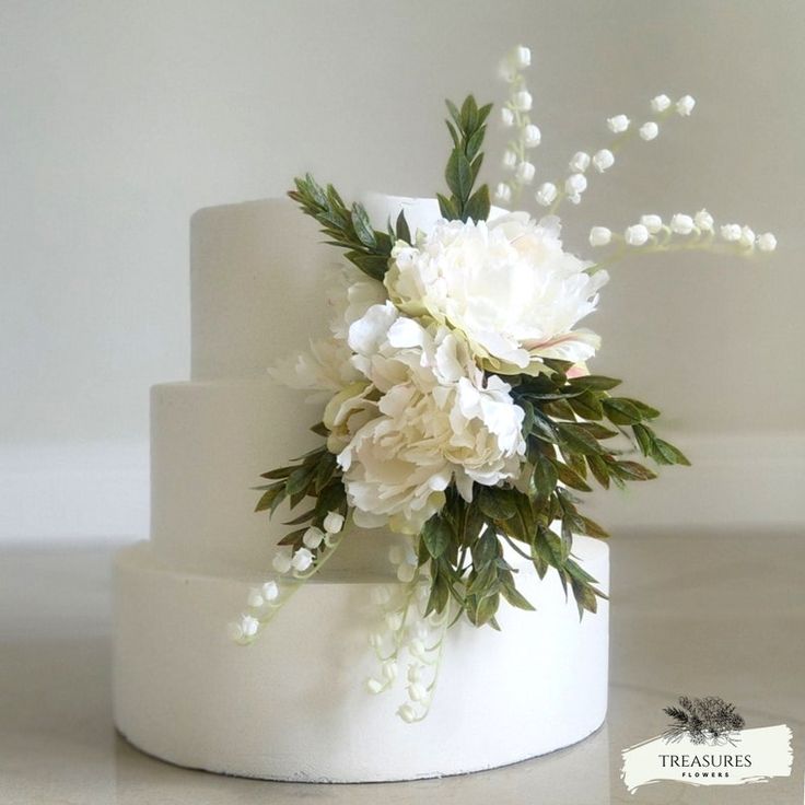 a white wedding cake with flowers on top