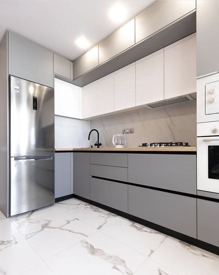 a modern kitchen with marble flooring and stainless steel appliances