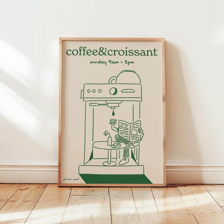 a coffee and croissant poster sitting on top of a hard wood floor next to a white wall