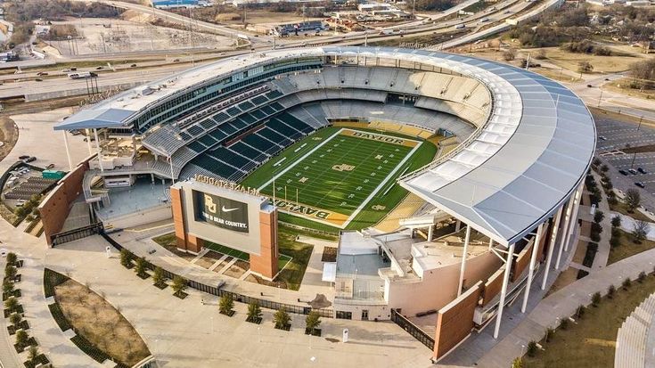 an aerial view of a football stadium with the field and parking lot in front of it