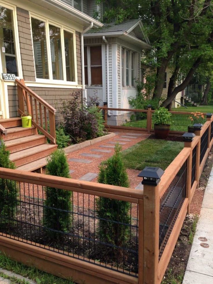 a fenced in yard with steps and plants on the side walk next to it