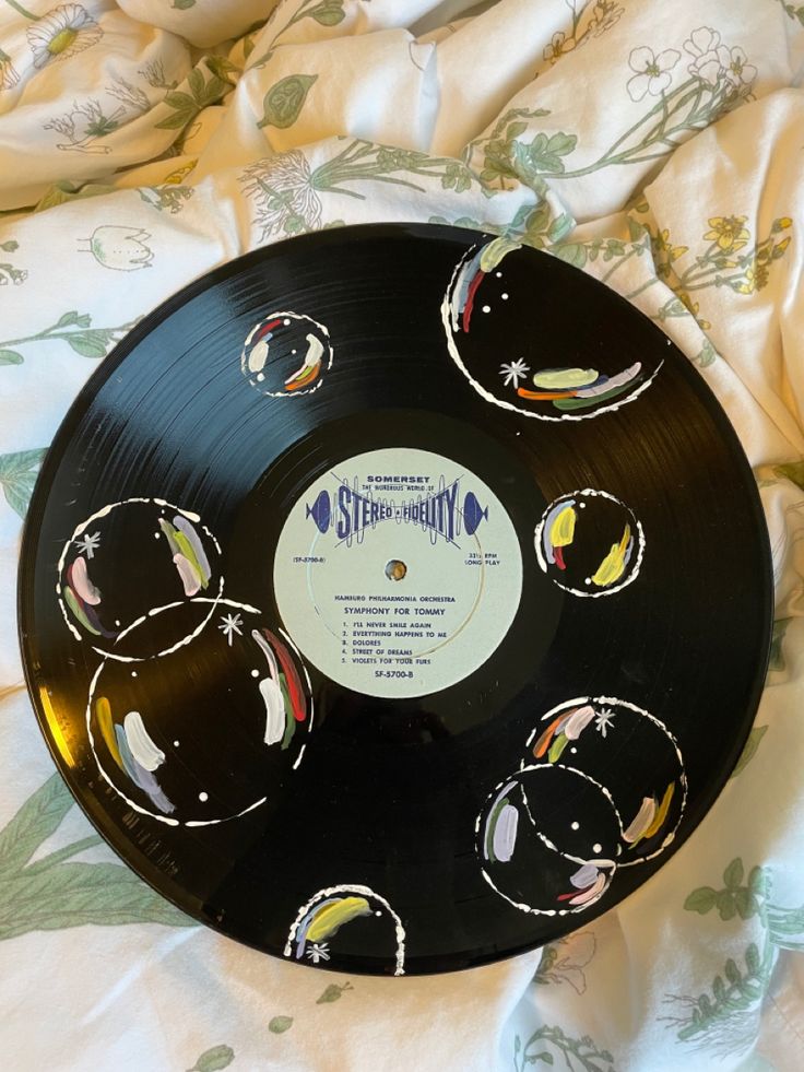 a black record sitting on top of a bed