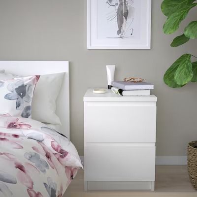 a bedroom with a bed, nightstand and plant