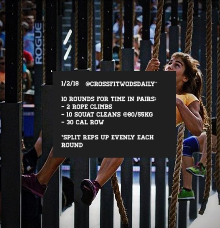 a woman is hanging on a rope in front of a sign that says crossfit