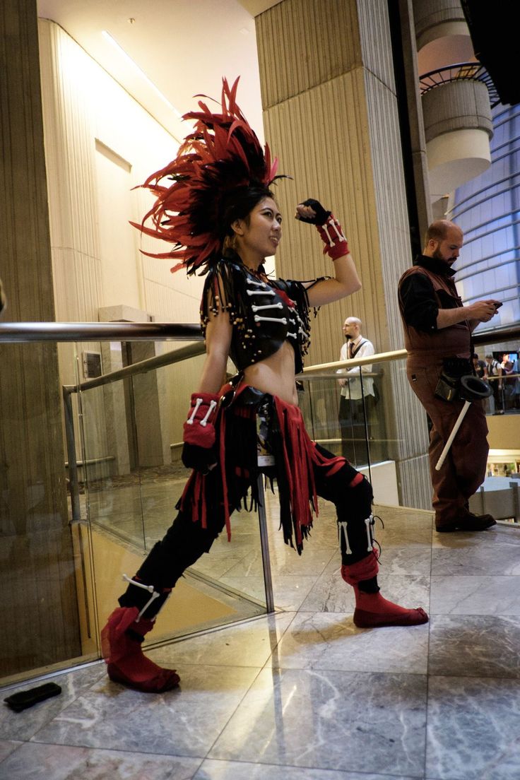 a woman dressed in costume standing on a stair case with her hair blowing in the wind