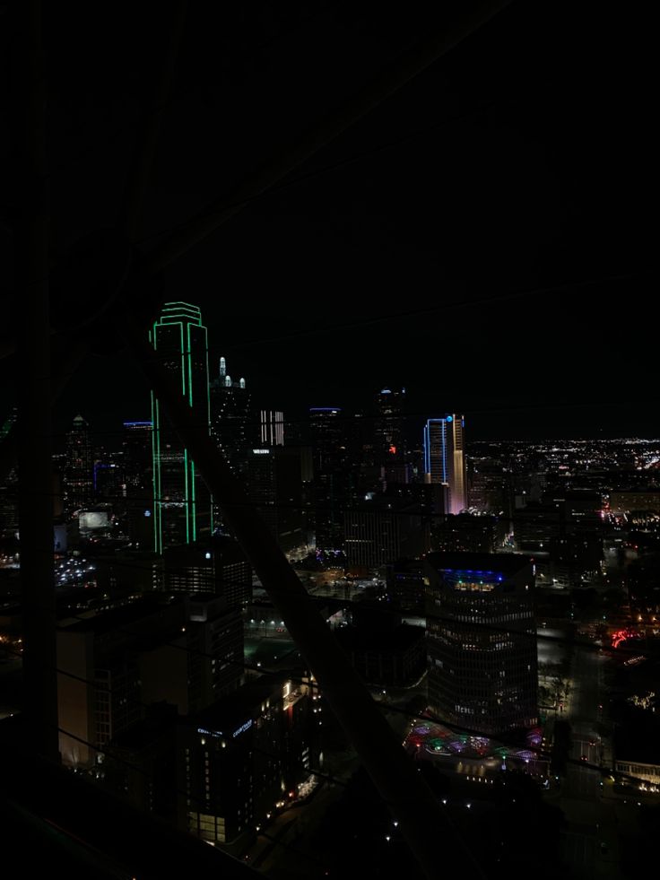 the city lights shine brightly at night in this view from an observation point on top of a skyscraper