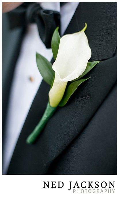 a man in a tuxedo with a white flower on it's lapel