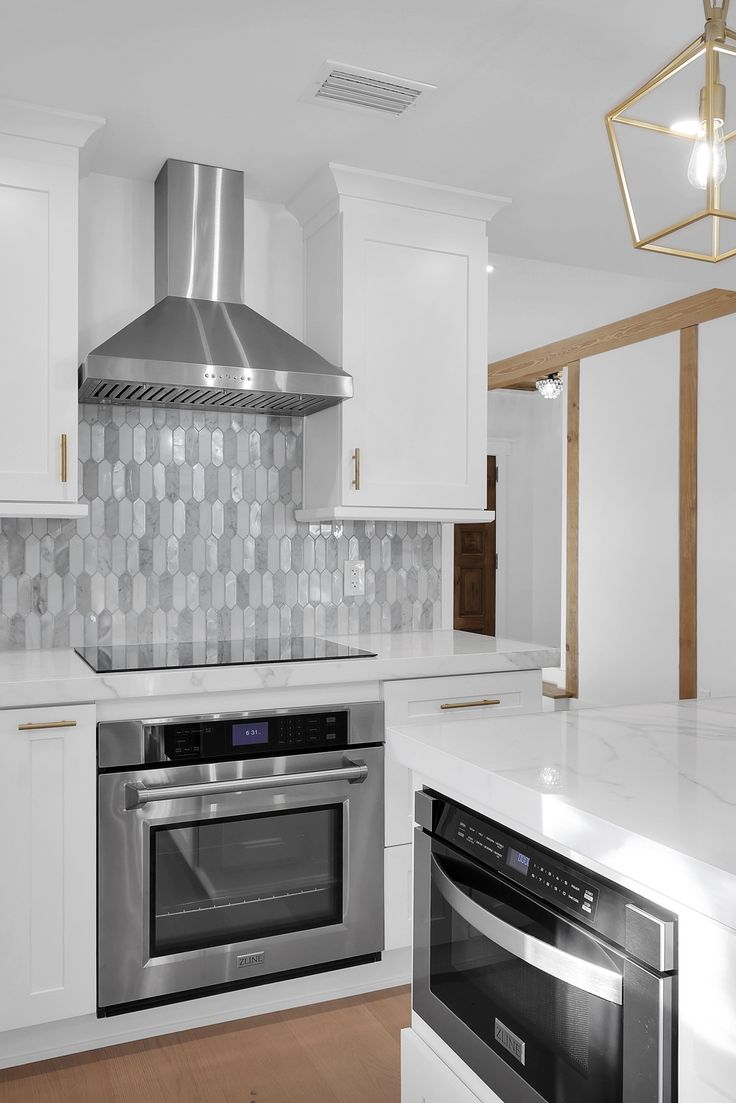 a kitchen with white cabinets and stainless steel appliances