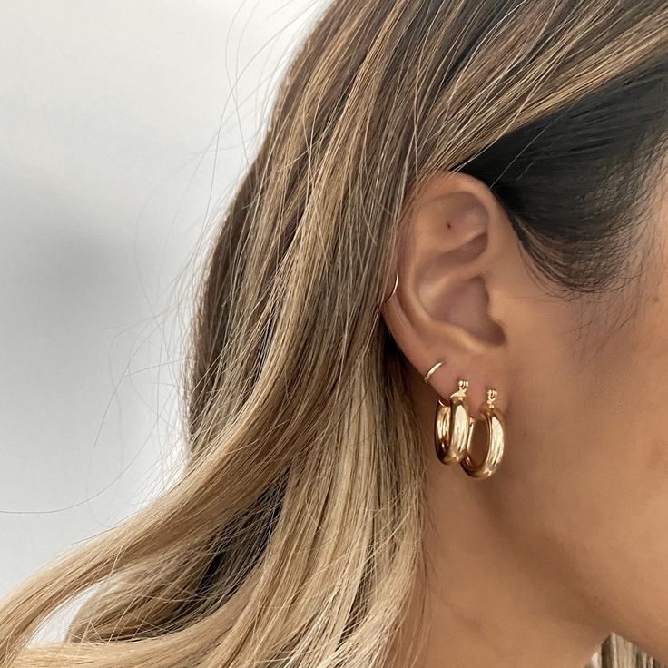 a woman wearing large gold hoop earrings