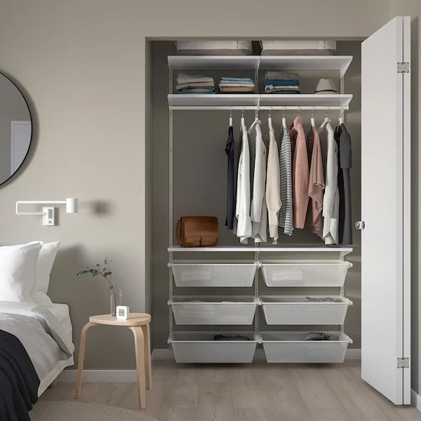 an organized bedroom closet with clothes hanging on the shelves and storage bins under it