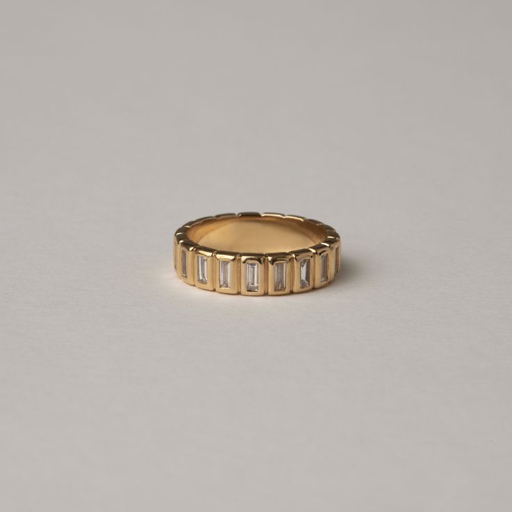 a gold ring with baguets on the side