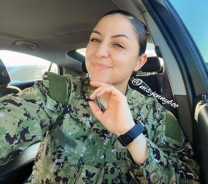 a woman in uniform is sitting in the back seat of a car and smiling at the camera