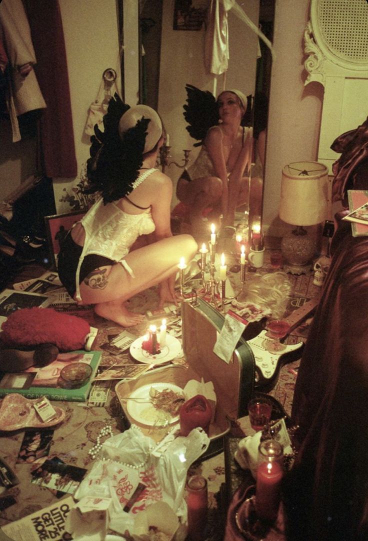 two women sitting on the floor with candles in front of them and other items scattered around