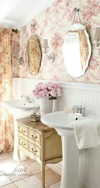 a bathroom with floral wallpaper and two sinks