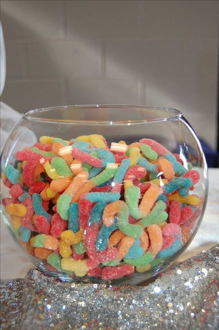 a bowl filled with gummy bears sitting on top of a table