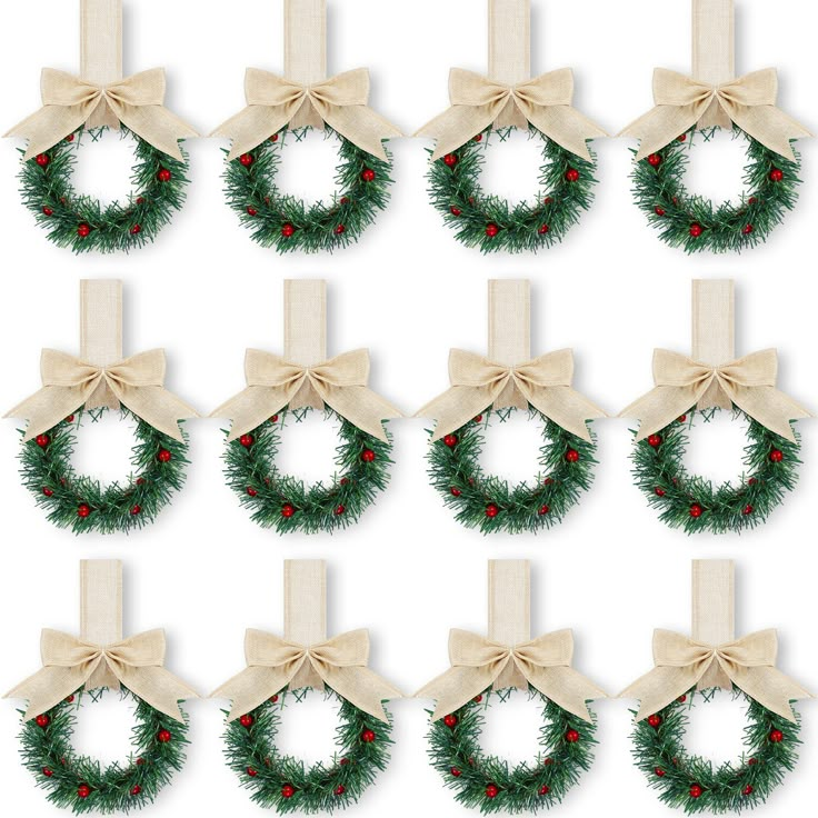 twelve christmas wreaths with bows and berries on them, all tied in burlocks