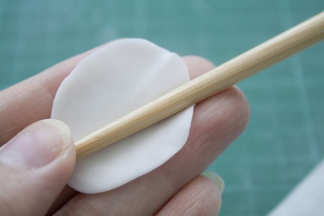 a person holding a chopstick in their left hand and an egg on the other