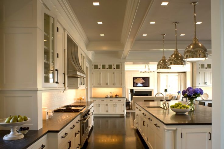 a large kitchen with white cabinets and black counter tops