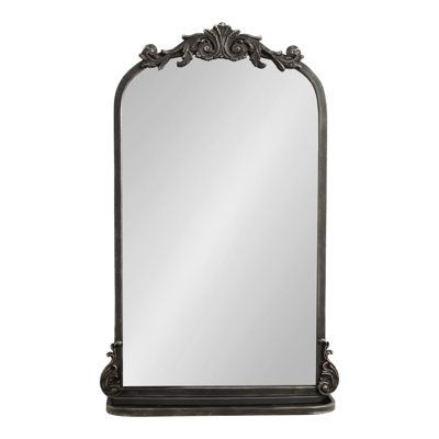 an ornate black mirror on a white background with clippings to the bottom right