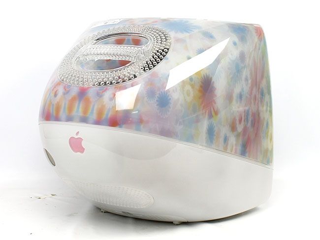 an apple computer sitting on top of a white surface with colorful designs and diamond accents