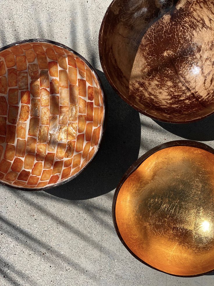 three bowls are sitting on the ground next to each other and one has a piece of bread in it