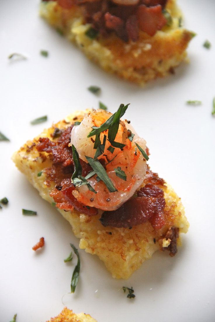 two pieces of food on a plate with garnishes and seasoning sprinkles