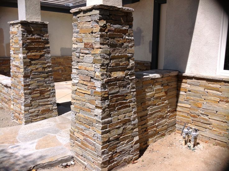 two stone pillars in front of a house with no doors or windows on the outside