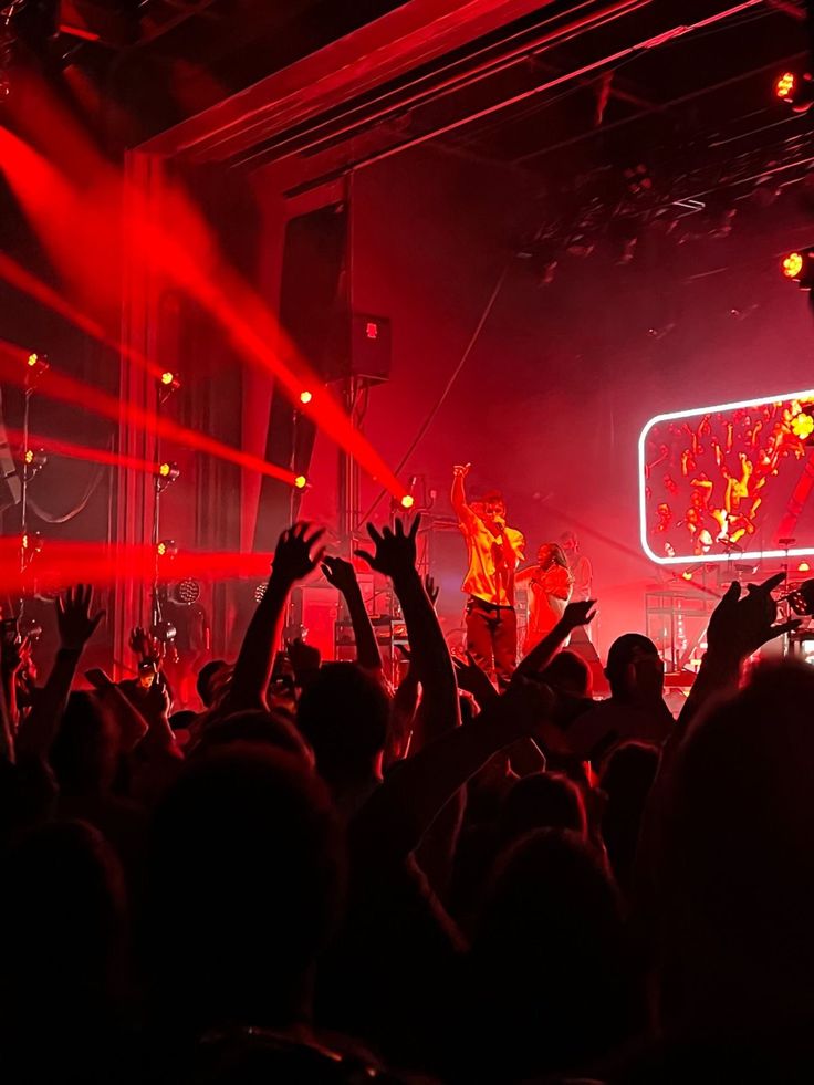 a group of people standing on top of a stage with their hands in the air